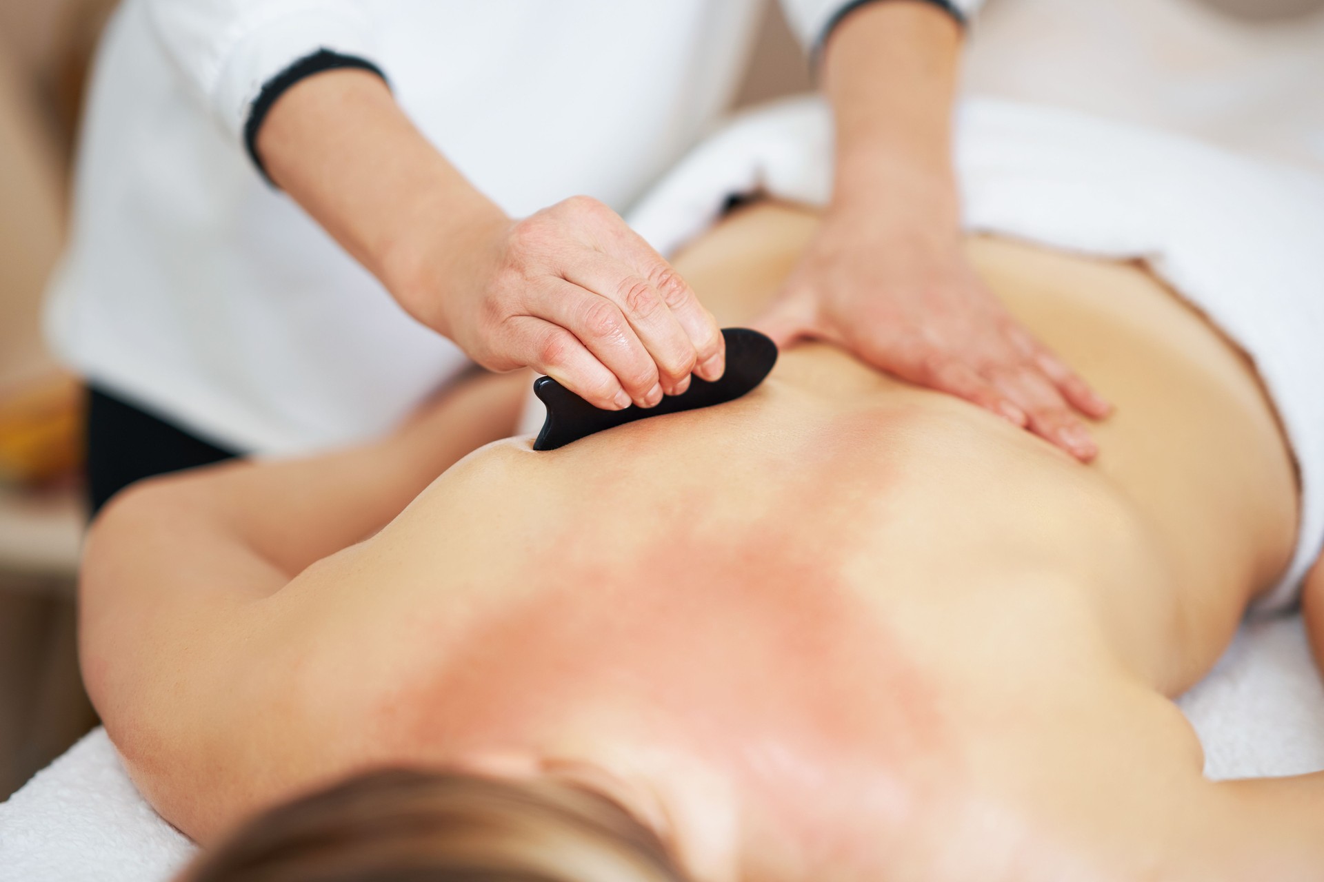 Woman having a gua sha massage in salon