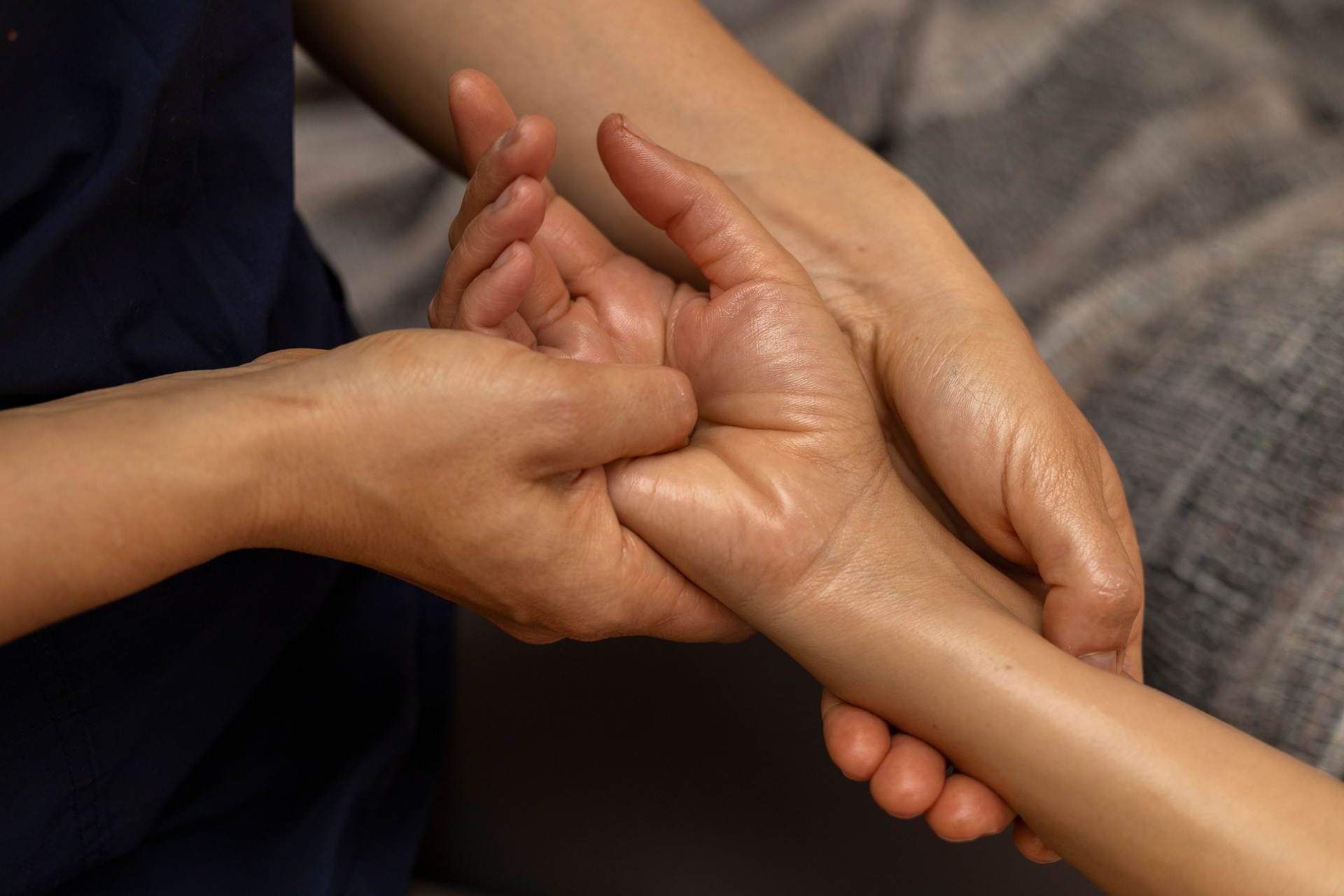 Latina woman lying on her back receiving an ayurvedic massage treatment in her hands